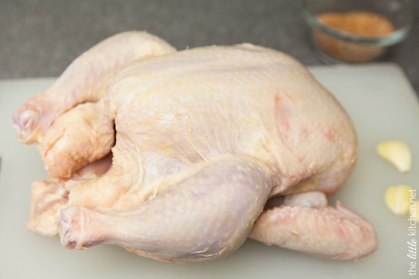 whole chicken on a cutting board with garlic