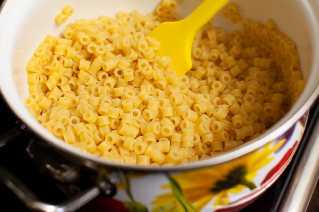 cooked pasta noodles in a pot with a rubber spatula