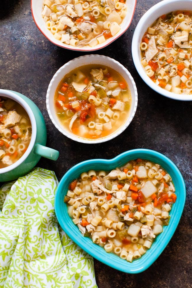 Spicy Chicken Soup in various sized and shaped bowls with a green towel