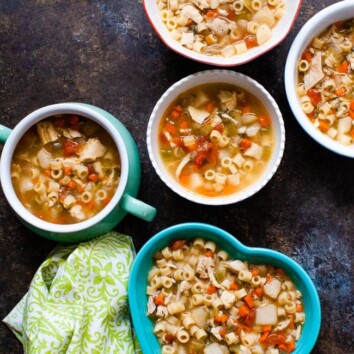 Chicken noodle soup in various shaped bowls with a green towel