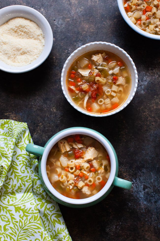 sicilian chicken soup in a couple of different bowls and a green towel