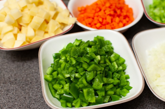 chopped green peppers and other vegetables in the background