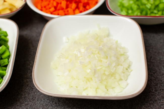 chopped onions and other vegetables in the background