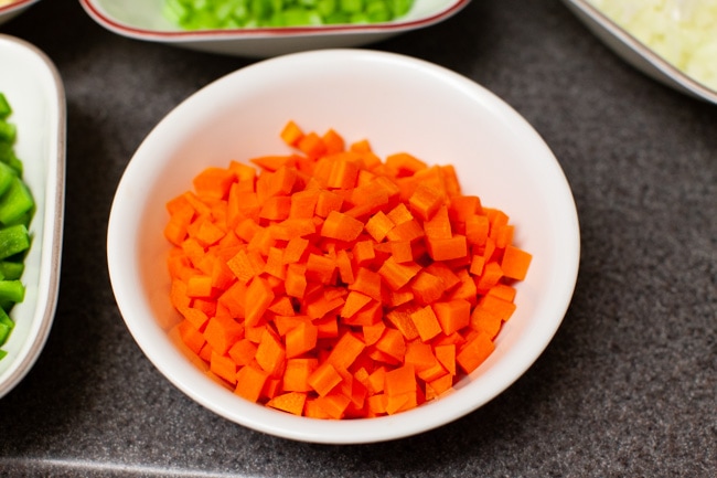 chopped carrots and other vegetables in the background