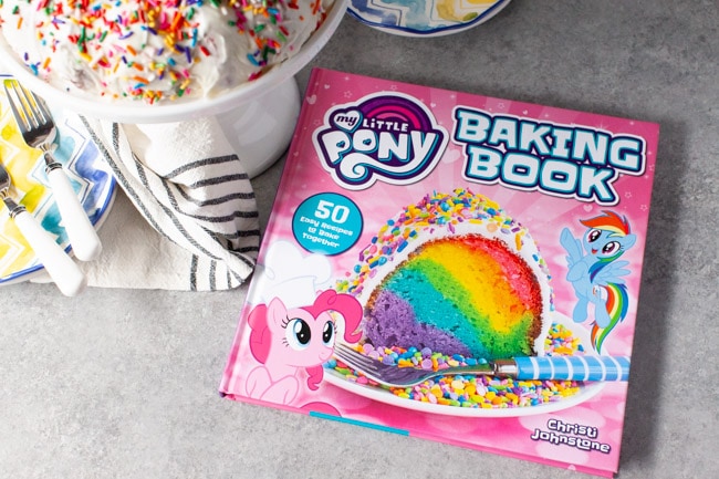 My Little Pony Baking Book next to cake plate with rainbow bundt cake