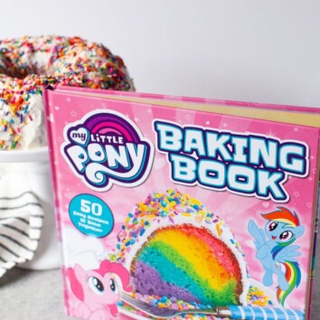 My Little Pony Baking Book standing in front of tray of rainbow bundt cake