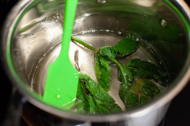 making simple syrup in a sauce pan with mint