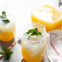 orange mint tea in a mason jar with straws
