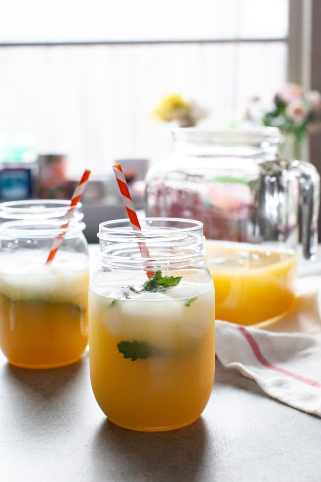 orange mint tea in mason jars just inside a window with flowers