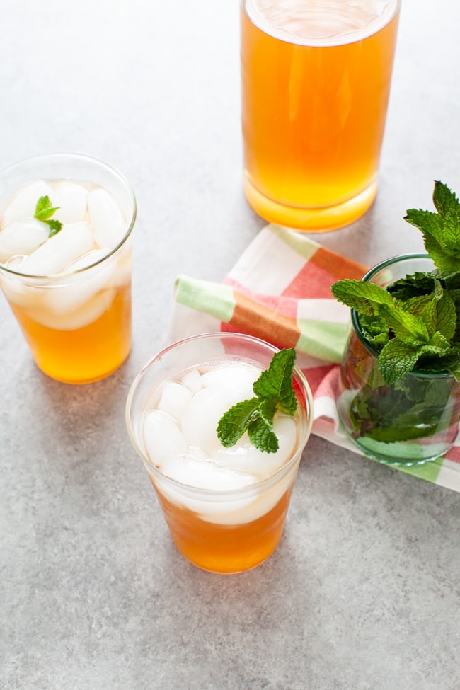 glasses with sweet tea vodka and lemonade with fresh mint in a glass in the background