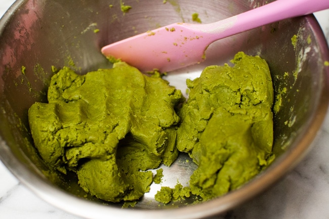 Matcha Cookie batter in metal mixing bowl with pink rubber spatula from thelittlekitchen.net