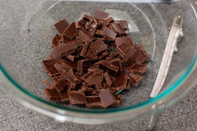 Glass bowl filled with roughly chopped chocolate pieces from thelittlekitchen.net