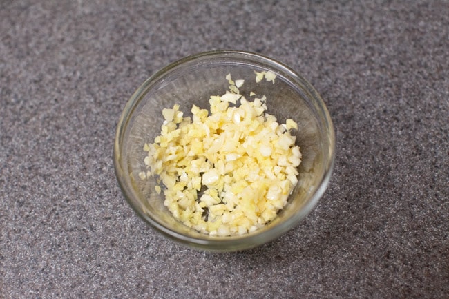 Small glass bowl with mixture of minced ginger, garlic, and oil