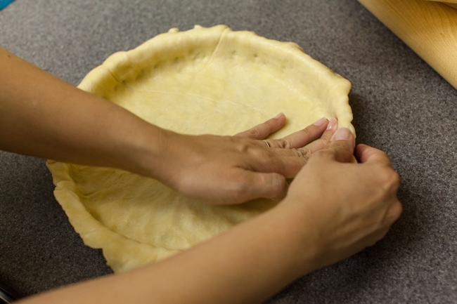 Hands pressing Sugar Pie dough into tart pan