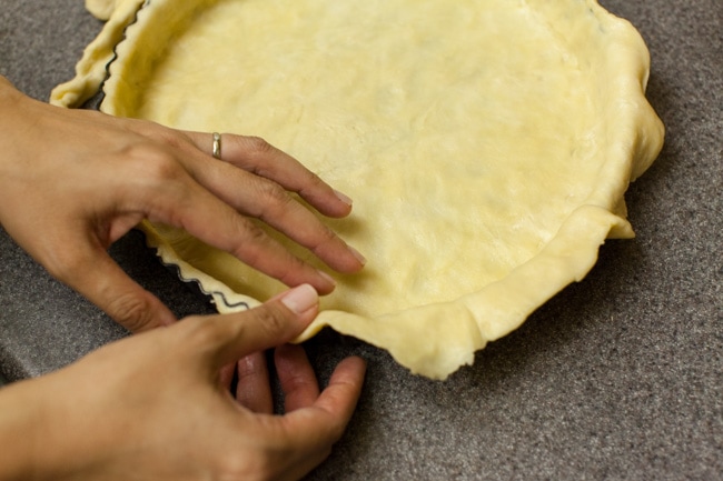 Hands pressing Sugar Pie dough into tart pan