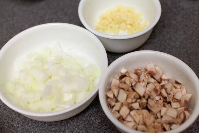 bowls with chopped onions, chopped garlic and chopped mushrooms