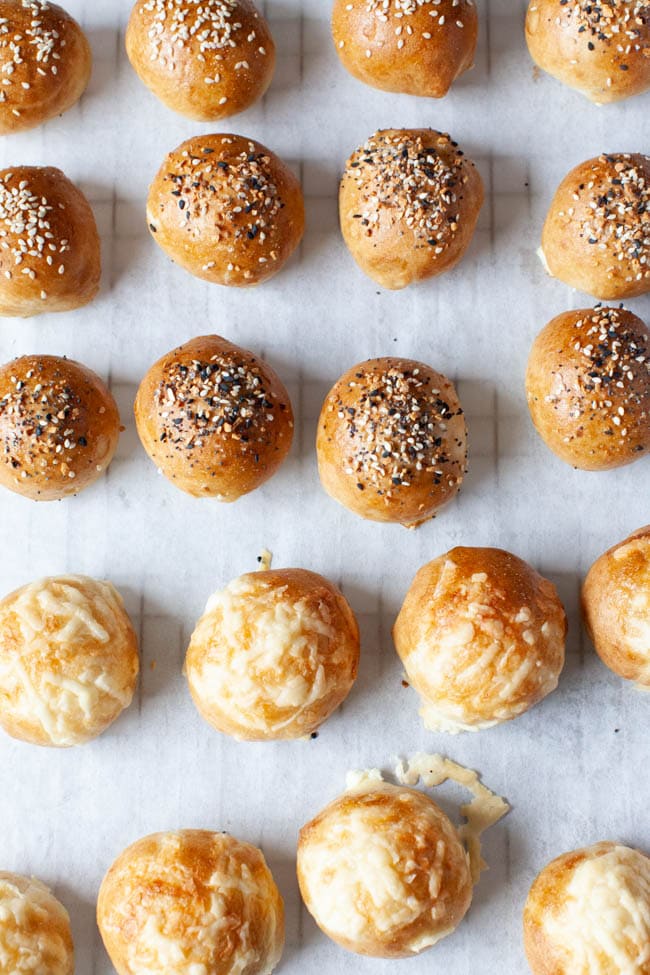 rows of stuffed bagel bites with toppings on parchment paper