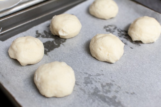 stuffed bagel bites on a parchment paper lined baking sheet