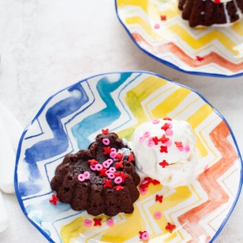 heart shaped chocolate cake with vanilla ice cream on a plate with another plate in the background