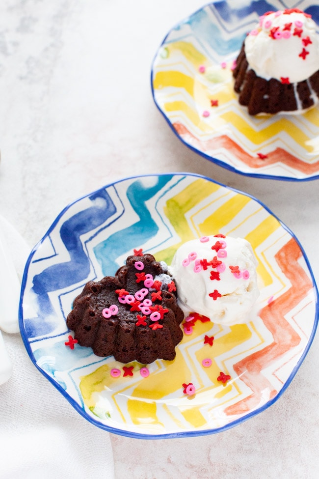 heart shaped chocolate cake with vanilla ice cream on a plate with another plate in the background