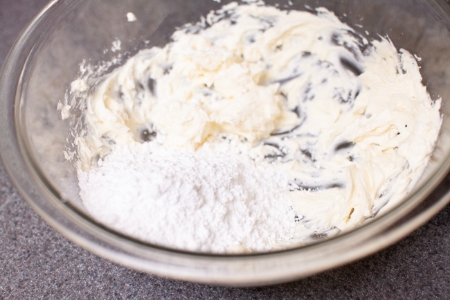 making cream cheese frosting in a glass bowl