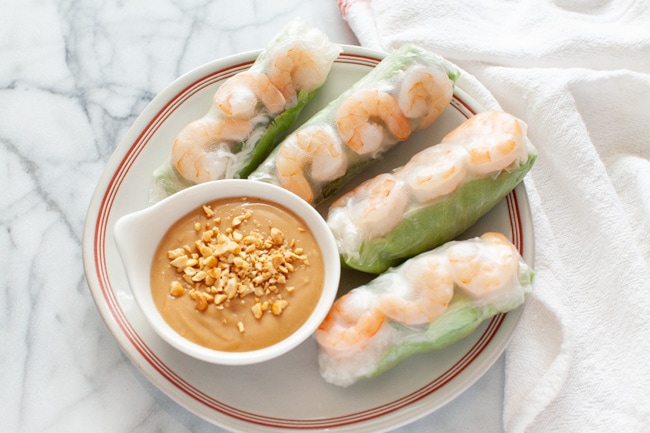 Vietnamese Spring Rolls with peanut dipping sauce on a plate with a napkin in the background