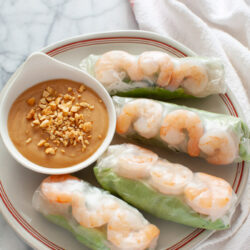 Vietnamese Spring Rolls with peanut dipping sauce on a plate with a napkin in the background