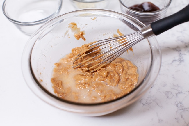 peanut butter and water in a mixing bowl making peanut sauce