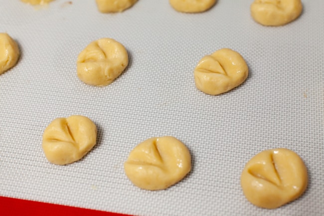 heart shaped thumbprint cookies on a silicon baking mat