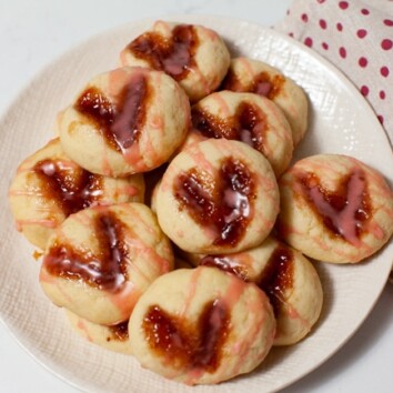 heart shaped thumbprint cookies on a plate with a napkin in the background