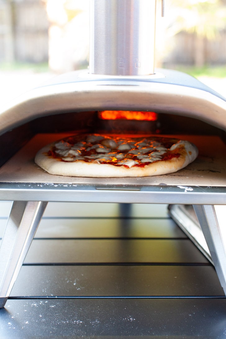 pizza cooking in an Ooni pizza oven