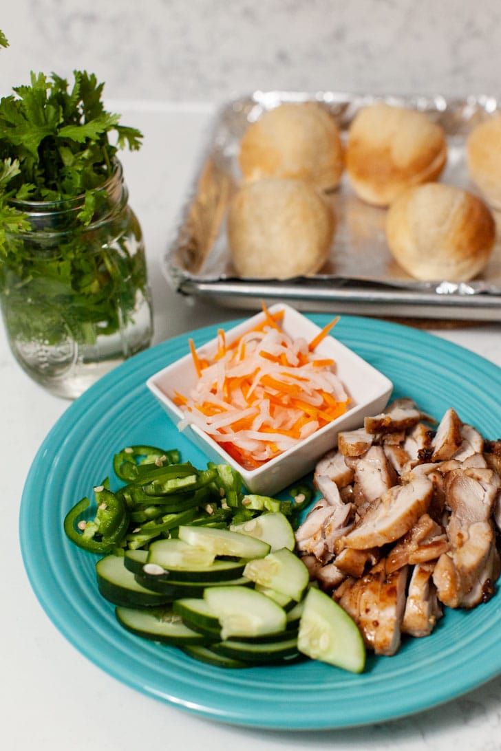 chicken and other ingredients on a plate to make banh mi sliders